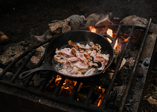 bacon cooking on open fire