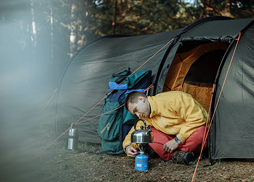 man cooking with camp gear